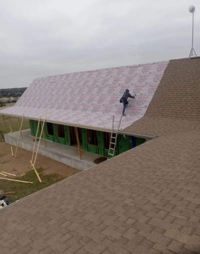 Worker preparing underlayment for a metal roof installation in Shippensburg